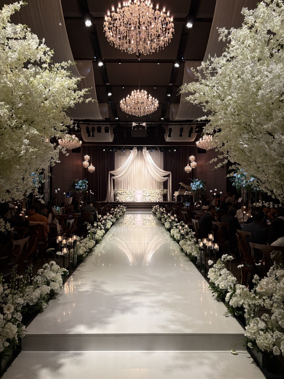 서울웨딩타워 웨딩홀 내부 버진로드와 높은 천고가 보이는 우아한 예식장 전경